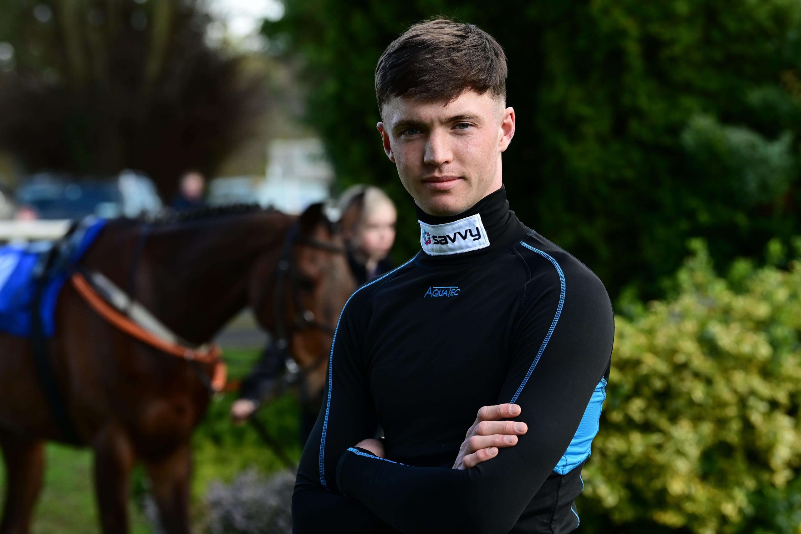 A professional photo of jockey Michael O'Sullivan with his horse in the background.
